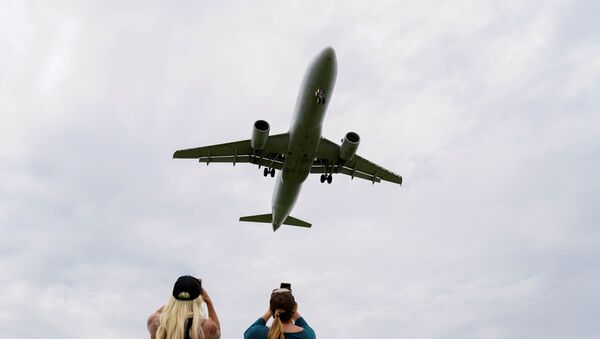 Flight attendants photograph a plane landing at Reagan National Airport during the coronavirus crisis while on a layover in Washington, U.S., April 29, 2020. - Sputnik International
