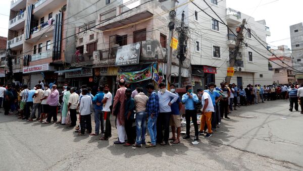 People stand in a queue to buy liquor outside a wine shop during an extended nationwide lockdown to slow the spread of COVID-19, in New Delhi, India, May 4, 2020.  - Sputnik International