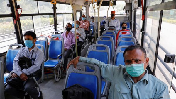 People wearing face masks travel in a bus, maintaining social distancing after few restrictions were lifted during an extended lockdown to slow the spread of the coronavirus disease (COVID-19) in New Delhi, India, May 20, 2020.  - Sputnik International