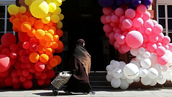 A muslim woman walks past balloons outside the National Hospital for Neurology and Neurosurgery, as the spread of the coronavirus disease (COVID-19) continues, in London, Britain, April 25, 2020 - Sputnik International