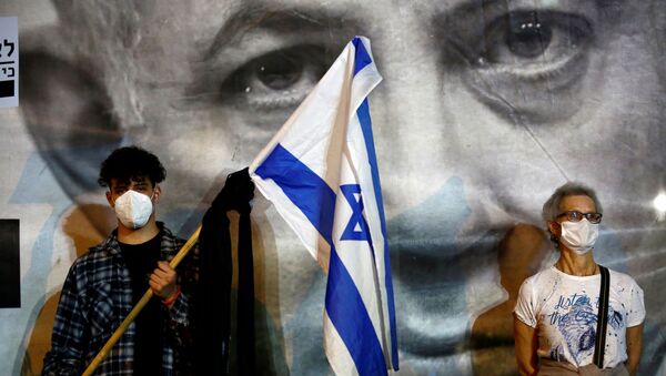 A man wearing a protective face mask holds an Israel's flag - Sputnik International