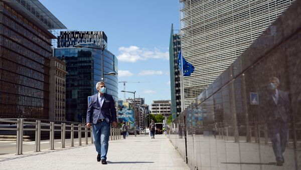 A man wearing a face mask walks past the European Commission headquarters as the spread of coronavirus disease (COVID-19) continues in Brussels, Belgium May 14, 2020 - Sputnik International