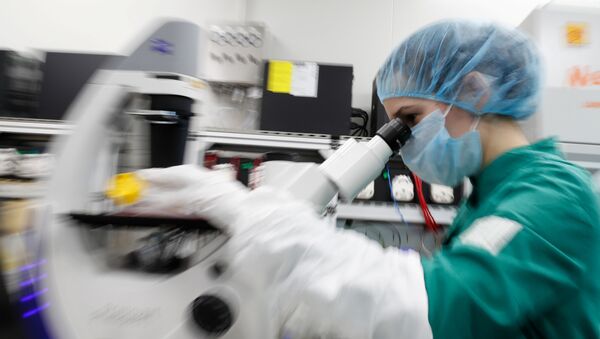 A scientist examines COVID-19 infected cells under a microscope during research for a vaccine against the coronavirus disease (COVID-19) at a laboratory of BIOCAD biotechnology company in Saint Petersburg, Russia May 20, 2020 - Sputnik International