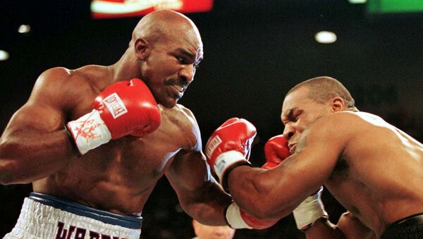 Evander Holyfield punches Mike Tyson in their second fight, in 1997 - Sputnik International