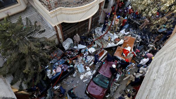 Rescue workers gather at the site of a passenger plane crash in a residential area near an airport in Karachi, Pakistan May 22, 2020.  - Sputnik International