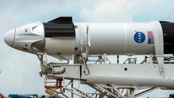 Crews work on the SpaceX Crew Dragon, attached to a Falcon 9 booster rocket, as it sits horizontal on Pad39A at the Kennedy Space Center in Cape Canaveral, Florida, U.S. May 26, 2020. - Sputnik International