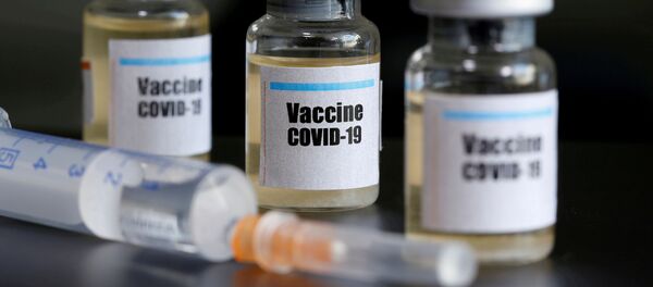 Small bottles labeled with a Vaccine COVID-19 sticker and a medical syringe are seen in this illustration - Sputnik International
