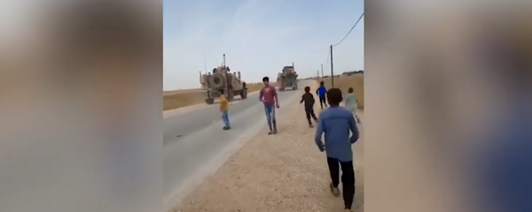 Syrian children running toward US military vehicles in al-Hasakah province, pelting them with rocks. - Sputnik International