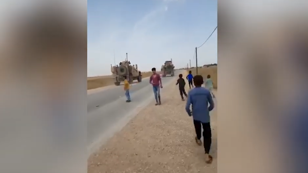 Syrian children running toward US military vehicles in al-Hasakah province, pelting them with rocks. - Sputnik International