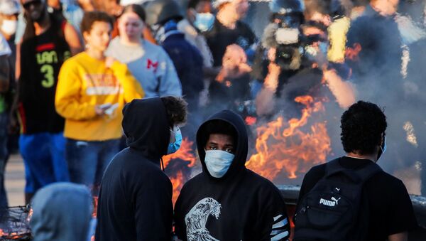 People around a burning car in Minneapolis - Sputnik International