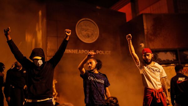 Protesters react after setting fire to the entrance of a police station as demonstrations continue after a white police officer was caught on a bystander's video pressing his knee into the neck of African-American man George Floyd, who later died at a hospital, in Minneapolis, Minnesota, U.S., May 28, 2020. - Sputnik International