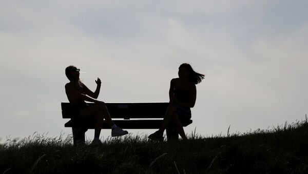 People sit on a bench in St Andrews as Scotland eases lockdown restrictions following the outbreak of the coronavirus disease (COVID-19), St Andrews, Scotland, Britain, May 29, 2020. - Sputnik International