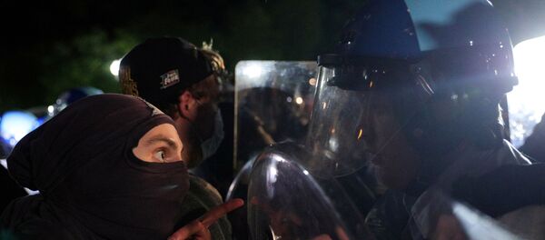 A protester faces a U.S. Secret Service uniformed division officer during a demonstration against the death in Minneapolis police custody of African-American man George Floyd, as the officers keep demonstrators away from the White House during a protest in Lafayette Park in Washington, U.S. May 30, 2020. - Sputnik International