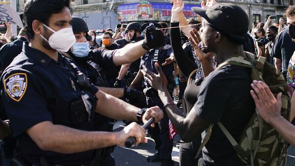 A NYPD police officer sprays protesters as they clash during a march against the death in Minneapolis police custody of George Floyd, in the Brooklyn borough of New York City, U.S., May 30, 2020. - Sputnik International