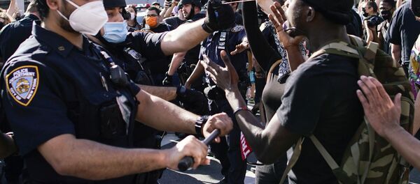 A NYPD police officer sprays protesters as they clash during a march against the death in Minneapolis police custody of George Floyd, in the Brooklyn borough of New York City, U.S., May 30, 2020. - Sputnik International