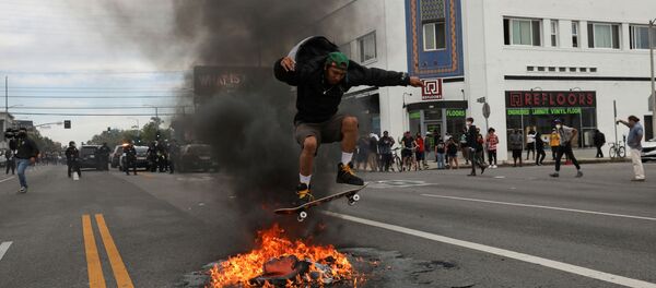 A man jumps with a skateboard over fire during a protest against the death in Minneapolis police custody of George Floyd, in Los Angeles, California, U.S., May 30, 2020. - Sputnik International