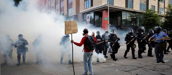 A protester faces riot police advancing through tear gas during nationwide unrest following the death in Minneapolis police custody of George Floyd, in Raleigh, North Carolina, US. - Sputnik International