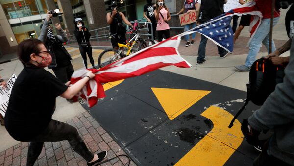 Protesters rip apart a US flag during nationwide unrest following the death in Minneapolis police custody of George Floyd, in Raleigh, North Carolina, US. - Sputnik International