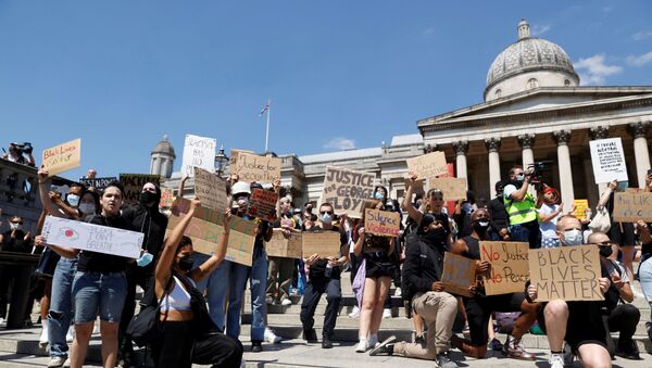 People holds signs during a protest in Trafalgar Square - Sputnik International