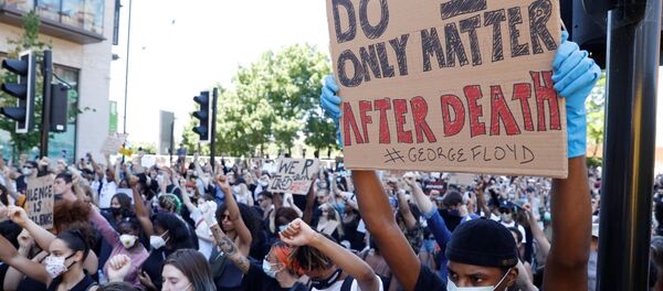 A man holds up a sign during a protest against the death in Minneapolis police custody of African-American man George Floyd in front of the US Embassy, London, Britain. - Sputnik International