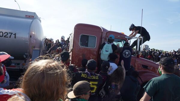 Protesters scale a truck that was driven into a rally  against the death in Minneapolis police custody of George Floyd on the I-35W bridge in Minneapolis, U.S., May 31, 2020. - Sputnik International