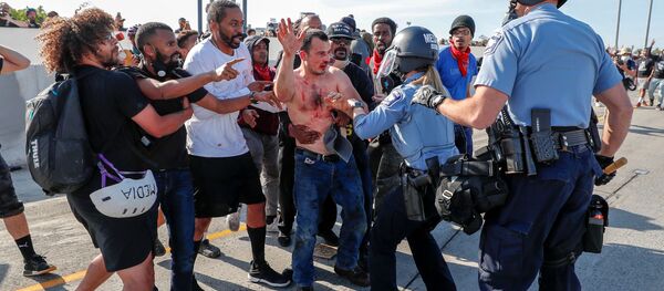 Protesters hand over to police the driver (C) of a tanker truck who drove into hundreds of protesters marching on 35W northbound highway during a protest against the death in Minneapolis police custody of George Floyd, in Minneapolis, Minnesota. - Sputnik International