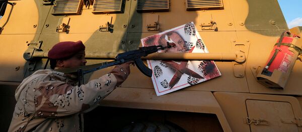 A member of Libyan National Army (LNA) commanded by Khalifa Haftar, points his gun to the image of Turkish President Tayyip Erdogan hanged on a Turkish military armored vehicle, which LNA said they confiscated during Tripoli clashes, in Benghazi, Libya January 28, 2020 A member of Libyan National Army (LNA) commanded by Khalifa Haftar, points his gun to the image of Turkish President Tayyip Erdogan hanged on a Turkish military armored vehicle, which LNA said they confiscated during Tripoli clashes, in Benghazi, Libya January 28, 2020 - Sputnik International