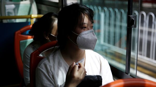 Woman wearing a face mask rides on a bus with her husband and friends to a shopping mall to look for a job in Beijing - Sputnik International