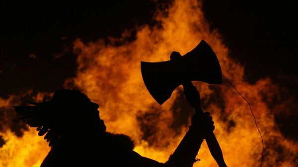 A man dressed as an ancient Viking warrior holds his axe aloft as a Viking Long boat is set alight to mark the traditional start of the New Year celebrations on Carlton Hill, Edinburgh, Scotland, Wednesday Dec. 29, 2004 - Sputnik International