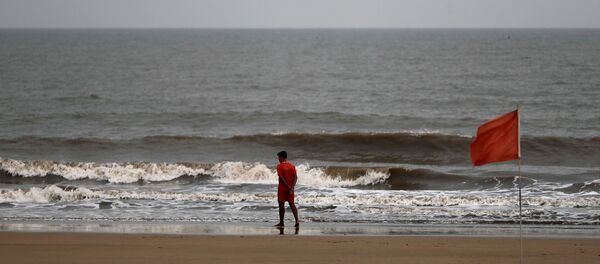 A lifeguard walks along the shore off the Arabian Sea before cyclone Nisarga makes its landfall, in Mumbai, India, June 2, 2020. REUTERS/Francis Mascarenhas - Sputnik International