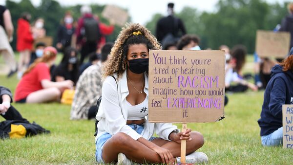 A woman wearing a face mask holds a banner in Hyde Park during a Black Lives Matter protest following the death of George Floyd who died in police custody in Minneapolis, London, Britain, June 3, 2020 - Sputnik International