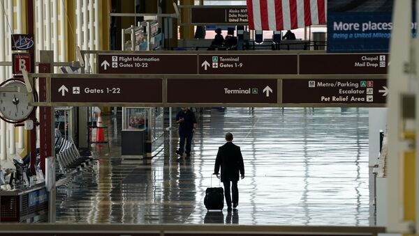 FILE PHOTO: A lone passenger walks through Reagan National airport as the outbreak of the novel coronavirus (COVID-19) pandemic continues to keep airline travel at minimal levels and the U.S. economy contracts in the first quarter at its sharpest pace since the Great Recession, in Washington, U.S. April 29, 2020 - Sputnik International