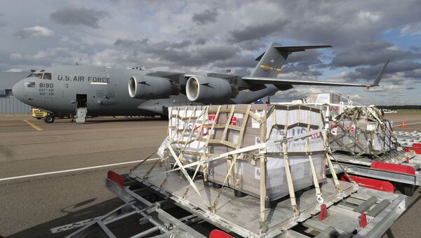 A tractor pulls the first batch of medical aid from the United States, including 50 ventilators as a donation to help the country tackle the coronavirus outbreak, from a US Air Force C-17 Globemaster transport plane upon its landing at Vnukovo International Airport outside Moscow, Russia, 21 May 2020. - Sputnik International