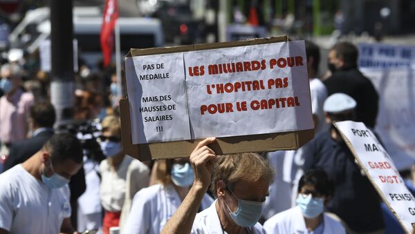 Parisian Healthcare workers hold a placard reading billions for hospitals, not for the capital as they gather during a demonstration in front of the Robert Debre hospital to call for better working conditions and an increase of manpower as French government launched general talks on Health, on May 28, 2020, in Paris - Sputnik International