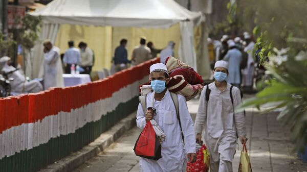 Muslim pilgrims walk towards a bus that will take them to a quarantine facility, amid concerns over the spread of the new coronavirus, at the Nizamuddin area of New Delhi, India, Tuesday, March 31, 2020 - Sputnik International