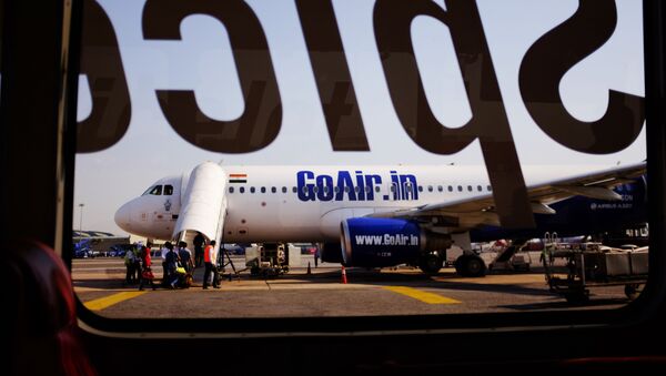 An airplane belonging to the Indian airline GoAir can be seen from this image taken through the glass of an airport bus at the Indira Gandhi International Airport in New Delhi on October 5, 2015 - Sputnik International