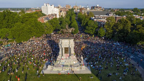 This Tuesday, June 2, 2020 file photo shows a large group of protesters gather around the statue of Confederate General Robert E. Lee on Monument Avenue near downtown in Richmond, Va. Virginia Gov. Ralph Northam is expected to announce plans Thursday for the removal of an iconic statue of Confederate Gen. Robert E. Lee from Richmond's prominent Monument Avenue. - Sputnik International