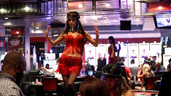 A woman wears a face shield as she dances behind blackjack tables during the reopening of The D hotel-casino, closed by the state since March 18, 2020 as part of steps to slow the spread of the coronavirus disease (COVID-19), in downtown Las Vegas, Nevada, U.S. June 4, 2020.  - Sputnik International