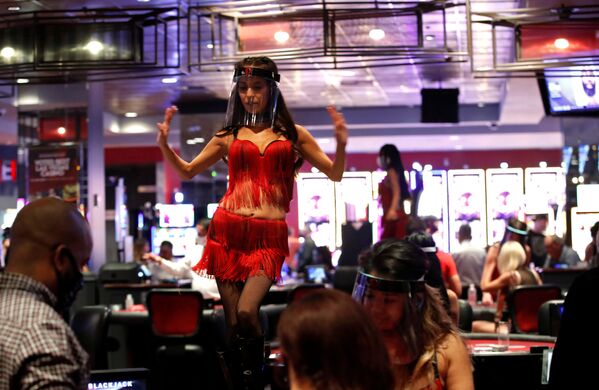 A woman wears a face shield as she dances behind blackjack tables during the reopening of The D hotel-casino, closed by the state since March 18, 2020 as part of steps to slow the spread of the coronavirus disease (COVID-19), in downtown Las Vegas, Nevada, U.S. June 4, 2020.  - Sputnik International