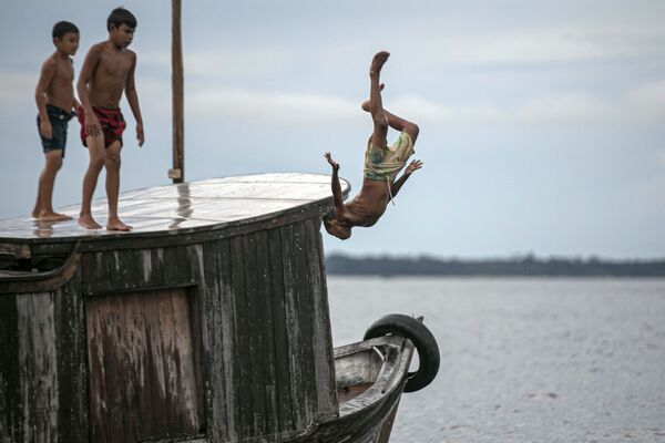 A child jumps into the water at Melgaco bay, southwest of the Marajo island, in Para state, Brazil, on May 29, 2020, amid the coronavirus pandemic.  - Sputnik International