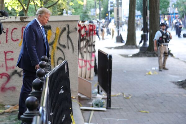 U.S. President Donald Trump walks past a building defaced with graffiti by protestors in Lafayette Park across from the White House after walking to St John's Church for a photo opportunity during ongoing protests over racial inequality in the wake of the death of George Floyd while in Minneapolis police custody, outside the White House in Washington, U.S., June 1, 2020.  - Sputnik International