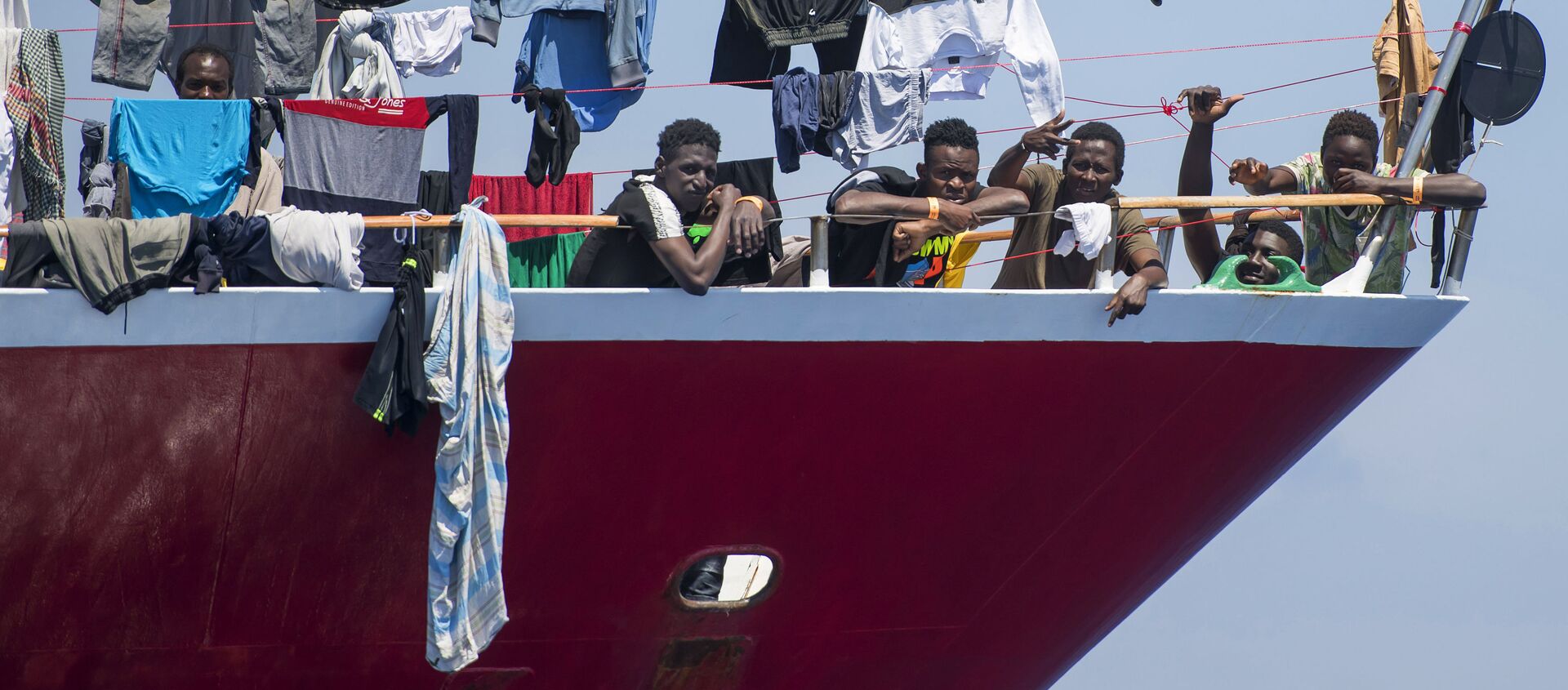 Migrants dry their clothes aboard a tourist boat some 20 kilometers from Malta, Tuesday, June 2, 2020. More than 400 migrants are living aboard pleasure cruise vessels, bobbing in the sea off Malta, many of them for weeks now. Rescued from human traffickers’ unseaworthy boats in several operations in the central Mediterranean since late April, the migrants, along with the Maltese government, are waiting for European Union countries to offer to take them. - Sputnik International, 1920, 23.09.2020
