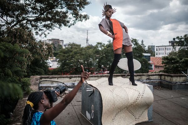 Kenyan photographer and art director Barbara Minishi (L) takes pictures of her room mate and fashion stylist Wambui Thimba (R) wearing a creation by a Kenyan fashion designer on the rooftop of their apartment in Nairobi, Kenya, on June 1, 2020. - Sputnik International