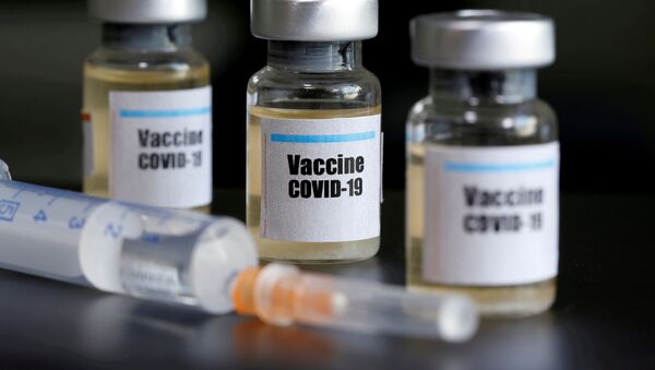 Small bottles labeled with a Vaccine COVID-19 sticker and a medical syringe are seen in this illustration taken taken April 10, 2020 - Sputnik International