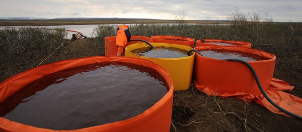 In this handout photo released by the press-service of Nornickel, employees of Marine Rescue Service work at a site where, on May 29, diesel fuel has leaked out of a tank at the TPP-3 thermal power station, outside Norilsk, Russia - Sputnik International