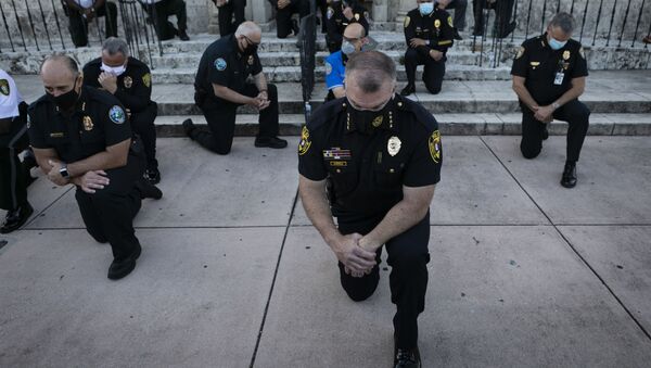 Police officers kneel during a rally in Coral Gables, Florida on May 30, 2020 in response to the recent death of George Floyd, an unarmed black man who died while being arrested and pinned to the ground by a Minneapolis police officer. - Sputnik International