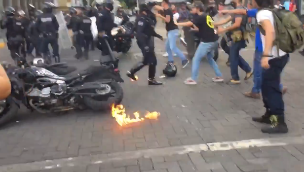 A police officer in Guadalajara, Mexico, puts out flames after being immolated by a protester - Sputnik International
