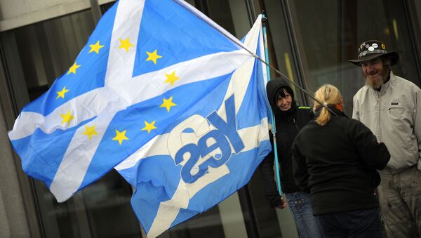 This picture shows pro-independence campaigners with one holding a 'yes' to independence flag and another holding a Saltire flag with EU logo design, outside the Scottish Parliament b - Sputnik International