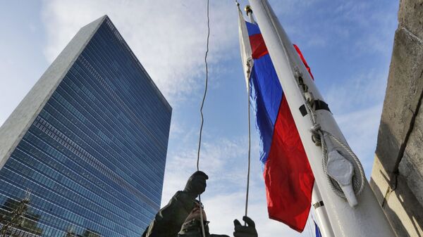 A United Nations security officer raises the Russian flag outside UN headquarters, Tuesday morning, 21 February 2017. - Sputnik International