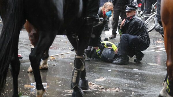 A colleague attends to a police officer who was injured when falling of a horse during scuffles with demonstrators at Downing Street during a Black Lives Matter march in London, Saturday, June 6, 2020, as people protest against the killing of George Floyd by police officers in Minneapolis, USA. - Sputnik International